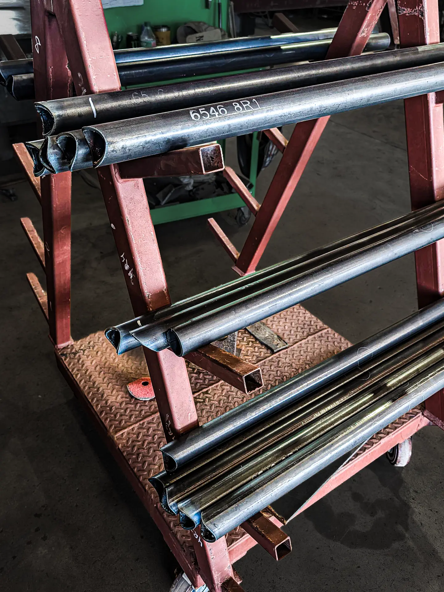 Coped pipe handrail sections staged on a rack at DeVille Steel