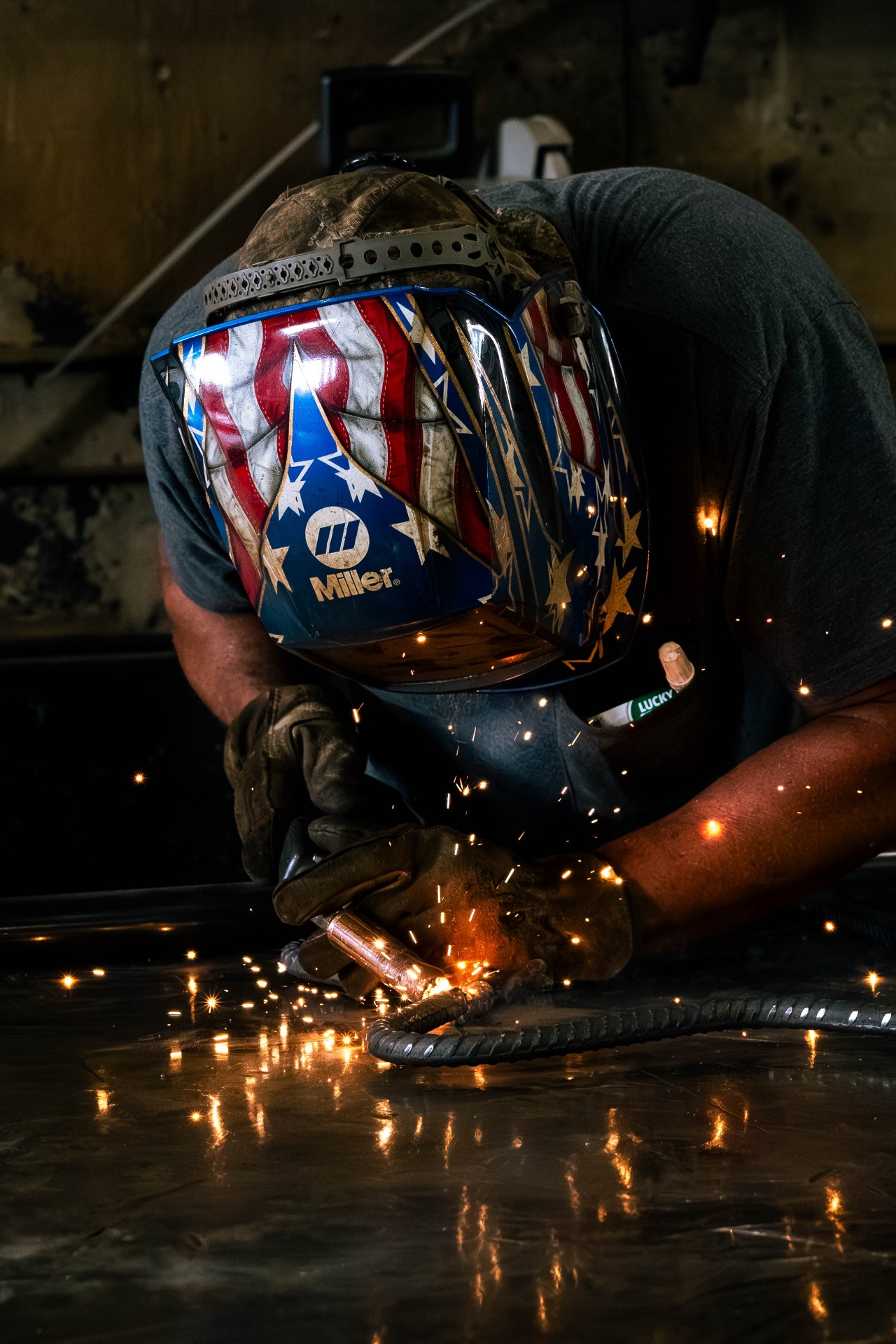 Welder in a stars-and-stripes hood laying a bead on rebar